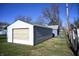 White detached garage with a roll-up door and side door at 3235 Adams St, Indianapolis, IN 46218