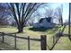 The house is nestled in a spacious backyard with a large tree at 3235 Adams St, Indianapolis, IN 46218