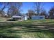 House with detached garage, situated on a grassy lot with mature trees at 3235 Adams St, Indianapolis, IN 46218