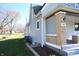 Side view of a light gray house with a brick porch and landscaping at 3235 Adams St, Indianapolis, IN 46218