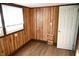 Room with wood paneled walls, hardwood floors and door at 3235 Adams St, Indianapolis, IN 46218