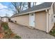 Tan house exterior with a gravel driveway and detached shed at 355 Mcclure Rd, Columbus, IN 47201