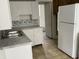 Kitchen features white cabinets, double sink and refrigerator at 430 S Proud St, Muncie, IN 47305