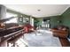 Living room with a grand piano, leather couches, and a stylish media cabinet at 6520 Cricklewood Rd, Indianapolis, IN 46220