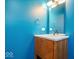 Modern bathroom with teal walls, wood vanity, and updated fixtures at 7650 Clarion Dr, Indianapolis, IN 46236