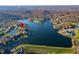 Aerial view of property located on the lake, surrounded by autumn trees at 9454 Raintree S Dr, Columbus, IN 47201
