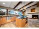 Open kitchen with island, stainless steel appliances, and a cozy fireplace at 9454 Raintree S Dr, Columbus, IN 47201