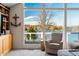 Relaxing lake view from sunroom with wall of windows and comfy seating at 9454 Raintree S Dr, Columbus, IN 47201