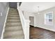 Carpeted staircase leading to upper level with dark gray wall and hardwood floor at 28 N Denny St, Indianapolis, IN 46201