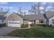 Tan colored house with gray roof, white garage door, and landscaped lawn at 3424 Bay Rd S Dr, Indianapolis, IN 46240