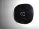 Ecobee smart thermostat installed on a white wall, displaying a temperature of 63 degrees at 443 N Centennial St, Indianapolis, IN 46222
