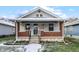 Brick bungalow with a front porch, steps, and small yard at 722 S Sherman Dr, Indianapolis, IN 46203