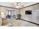 Living room with wood-paneled walls, ceiling fan, and view to dining area at 722 S Sherman Dr, Indianapolis, IN 46203