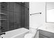 Modern bathroom featuring a gray tiled tub/shower combo and white countertop at 1230 N Alabama St, Indianapolis, IN 46202