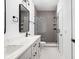 Modern bathroom with double vanity, marble countertop, and gray tiled shower at 1230 N Alabama St, Indianapolis, IN 46202