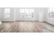 Bright, spacious living room with large windows and wood-look flooring at 1230 N Alabama St, Indianapolis, IN 46202