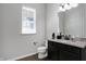 Modern bathroom with granite countertop, dark vanity, and a large mirror at 1710 Rossmay Dr, Westfield, IN 46074