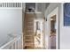 Upper hallway with ladder access to loft, hardwood floors, and bathroom access at 2264 Moon Shadow Ln, Indianapolis, IN 46280