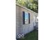 Side view of the house showcasing tan brick exterior and dark shutters at 3716 N Emerson Ne Ave, Indianapolis, IN 46218