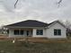 Rear view of a white farmhouse-style home with a covered porch at 5143 Oak Rdg Pl, Columbus, IN 47201