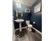 Powder room with dark blue walls, pedestal sink, and updated flooring at 16047 Barringer Ct, Westfield, IN 46074