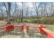 Spacious backyard with two red wooden benches and a tree line at 5457 Great Woods Dr, Indianapolis, IN 46224