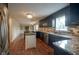 Modern kitchen with granite countertops, dark cabinetry, and a large island at 5837 Baron Ct, Indianapolis, IN 46250