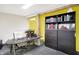 Home office with a large desk, built-in shelving, and yellow accent wall at 691 S 1100 E, Zionsville, IN 46077