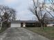 Front view of a ranch house with a driveway and mature trees at 734 Hattie Dr, Anderson, IN 46013