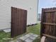 Dark stained wooden fence and gate, small stone path, and green grass at 8298 S Firefly Dr, Pendleton, IN 46064