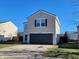 Tan two-story house with dark garage door at 8298 S Firefly Dr, Pendleton, IN 46064