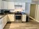 Galley kitchen with white cabinets, stainless steel appliances, and dark countertops at 2104 N Ball Ave, Muncie, IN 47304
