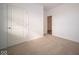 Simple bedroom with neutral walls and carpet, featuring a closet and access to another room at 5559 Tart Blvd, Indianapolis, IN 46239