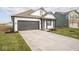 Two-car garage with a clean, modern design, featuring a white and gray color scheme and landscaped lawn at 5559 Tart Blvd, Indianapolis, IN 46239