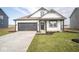 Modern farmhouse exterior boasts a white and gray color scheme, a two-car garage, and a manicured lawn at 5559 Tart Blvd, Indianapolis, IN 46239