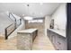 Basement bar with gray cabinets, a brick-look island, and a light-colored countertop at 16298 Grand Cypress Dr, Noblesville, IN 46060