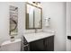 Modern powder room with dark vanity, white countertop, and gold accents at 16298 Grand Cypress Dr, Noblesville, IN 46060