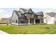 Gray farmhouse exterior with a landscaped lawn and a real estate sign at 5187 Abington Way, Zionsville, IN 46077