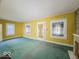 Living room with yellow walls and teal carpet, featuring multiple windows at 2118 N Dexter St, Indianapolis, IN 46202