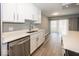 Updated kitchen featuring white cabinets, stainless steel dishwasher, and quartz countertops at 3965 N Meridian St # Apt 2A, Indianapolis, IN 46208