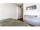 Bedroom with wood floors, a green duvet, a dresser, and white closet doors at 5133 Crittenden Ave, Indianapolis, IN 46205