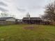 Covered back porch, large grassy yard, and wooden privacy fence at 6024 Boulder Dr, Anderson, IN 46013