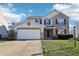 Two-story house with brick and siding exterior, two-car garage, and landscaped lawn at 6415 Kelsey Dr, Indianapolis, IN 46268