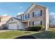 Two-story house with brick and vinyl siding, attached garage, and manicured lawn at 6415 Kelsey Dr, Indianapolis, IN 46268