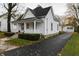 White house with a wraparound porch and a detached garage in the backyard at 7111 E Us Highway 52, Gwynneville, IN 46144