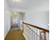 Upstairs hallway with carpeted flooring and wood railing at 8265 Plumwood Ln, Indianapolis, IN 46256