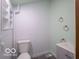 Simple bathroom with toilet, sink, and light green walls at 1115 N Kealing Ave, Indianapolis, IN 46201