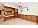 Retro kitchen with wood cabinets, a built in counter, and wood paneled walls at 1500 S Anderson St, Elwood, IN 46036