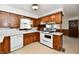 Retro kitchen features wood cabinets, white appliances, and a corner sink at 1500 S Anderson St, Elwood, IN 46036
