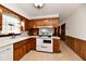 Retro kitchen with wood cabinets, white appliances and a corner sink at 1500 S Anderson St, Elwood, IN 46036